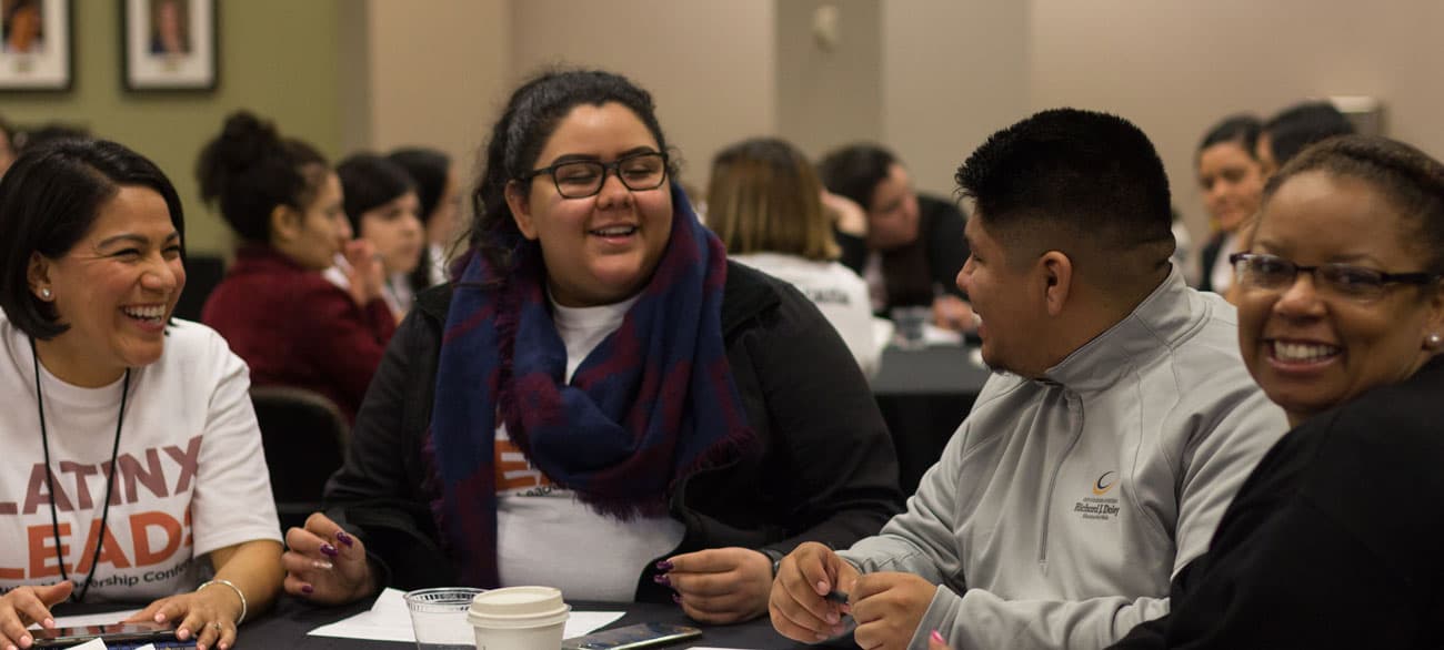 Attendees in conversation at conference tables