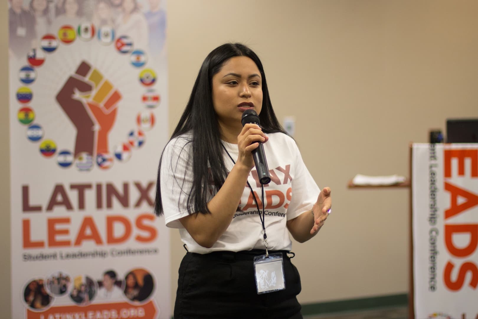 A Latinx Leads delegate speaking at the microphone during a session